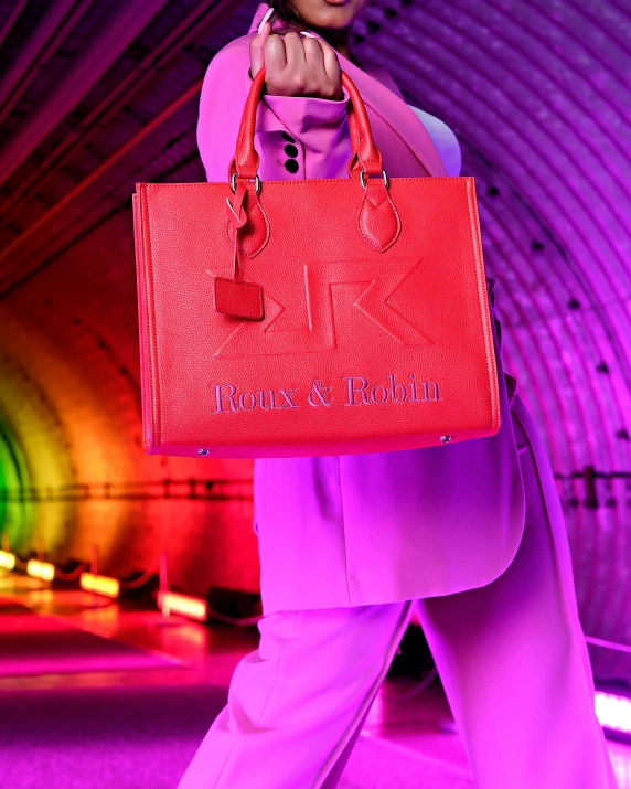 a woman with a red bag is walking down a runway