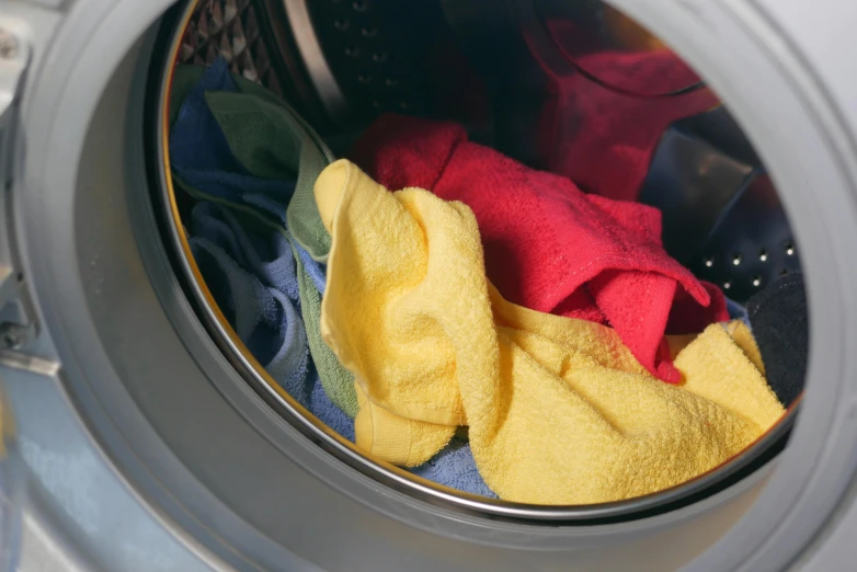 the washing machine is filled with several colors of towels