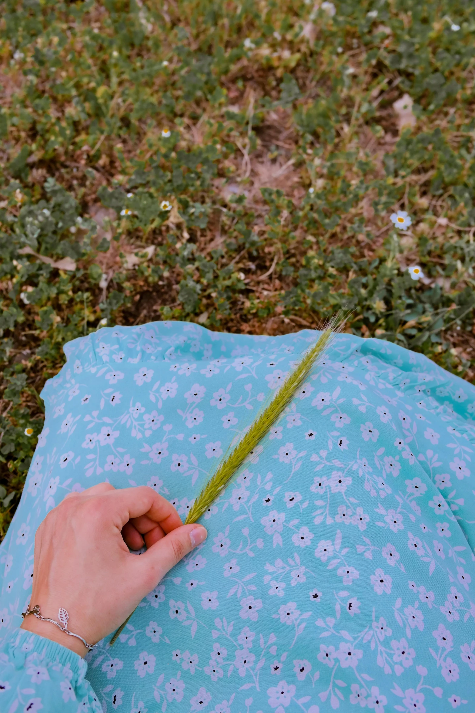 someone is laying down on the ground knitting