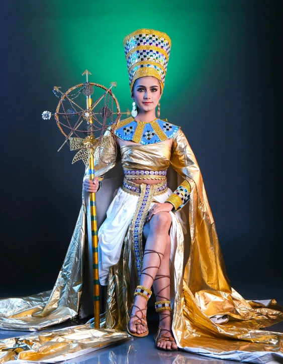 a woman in gold dress holding two umbrellas