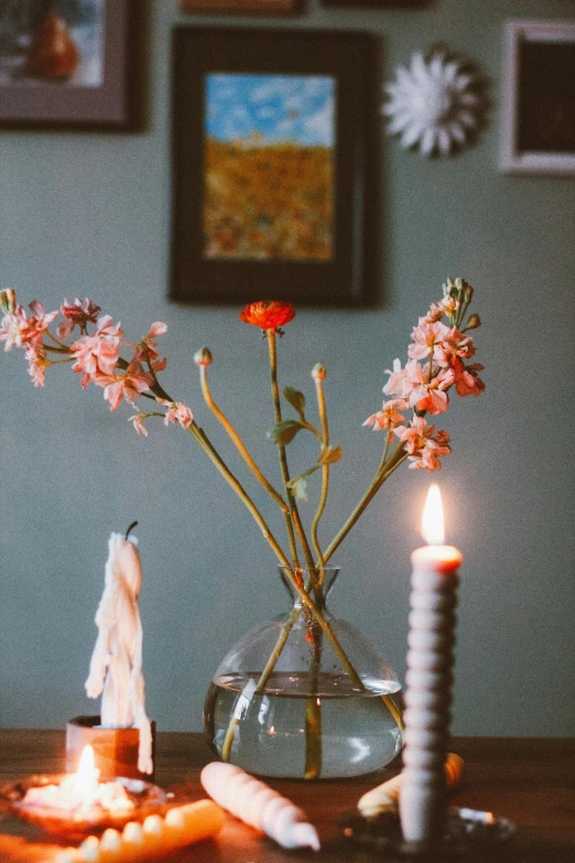 a table with a vase with flowers and candles