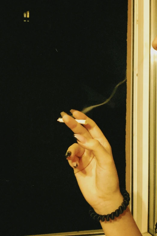 hand with a cigarette and a celet smoking cigarettes