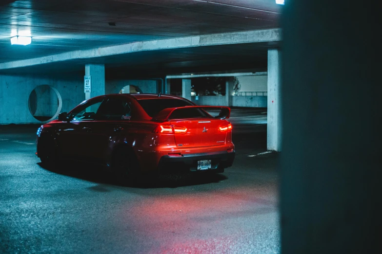 a red car in the dark in a parking garage