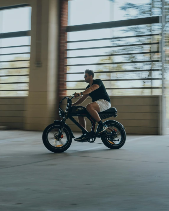 man on bicycle in parking lot near wall