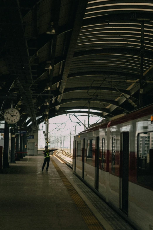 a person walking along side a train near a platform