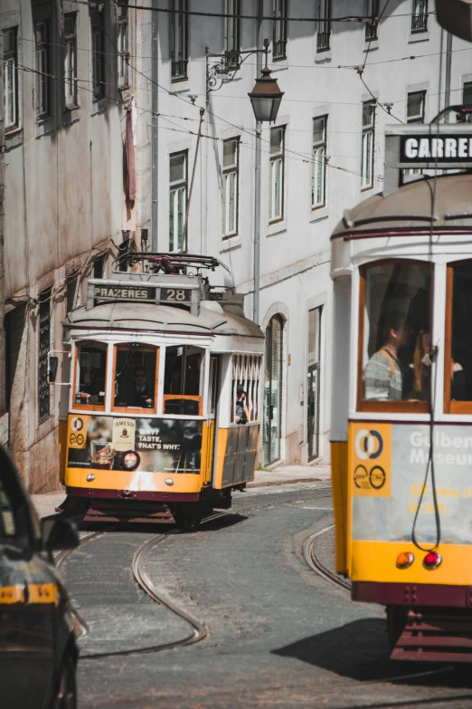 two trams on the tracks near old white buildings