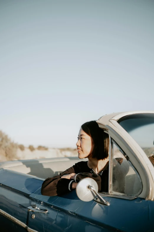 a woman riding in the back of a blue car