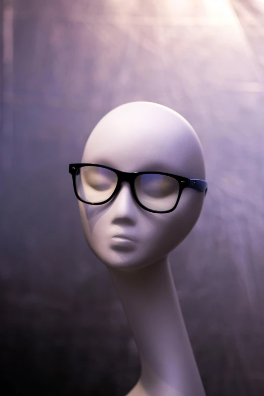 an open head mannequin wears black glasses