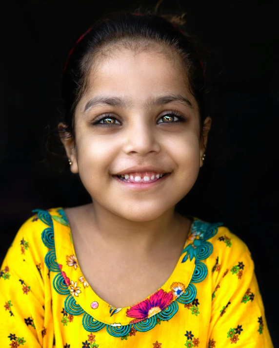 a girl with eyes open, in a yellow top