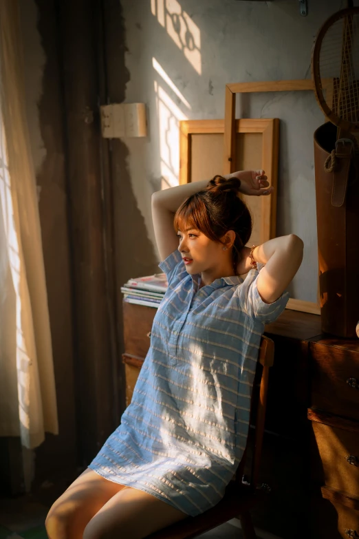 a woman sitting in an empty room wearing a shirt