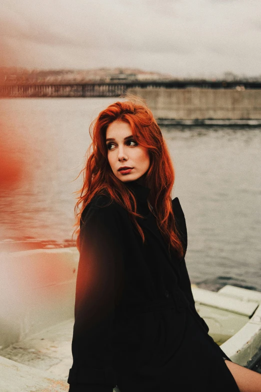 a woman with red hair is on a dock looking over her shoulder