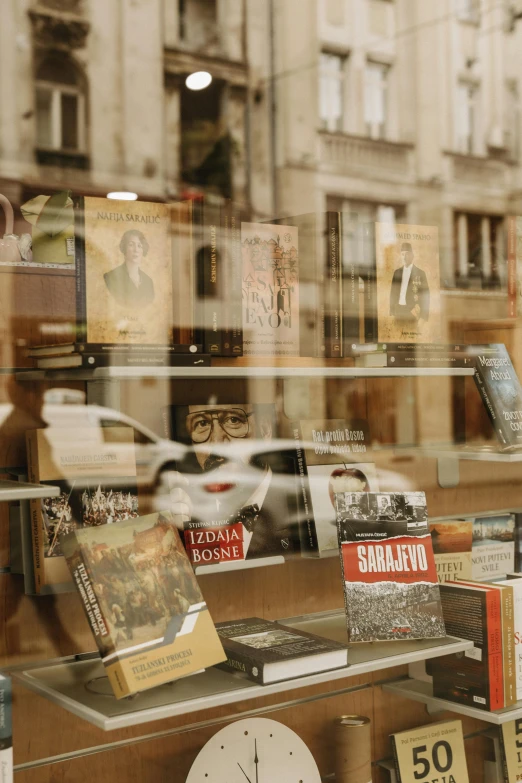 a store front window displays vintage books on the street