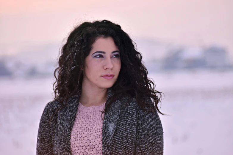 a woman standing in front of snow covered field