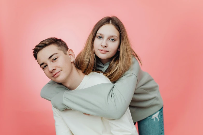 the girl is hugging the boy on the head