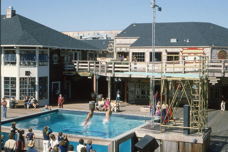 a group of people gather around a pool