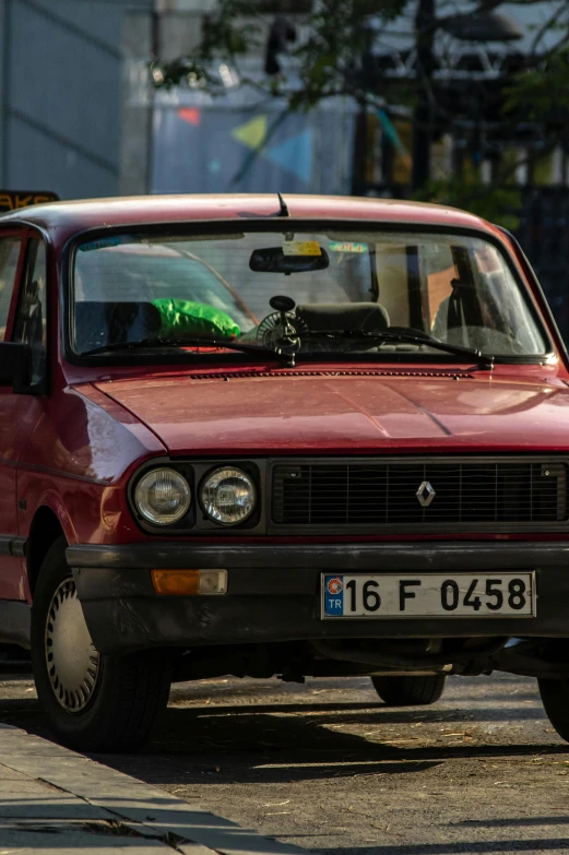 a red car is parked on a city street