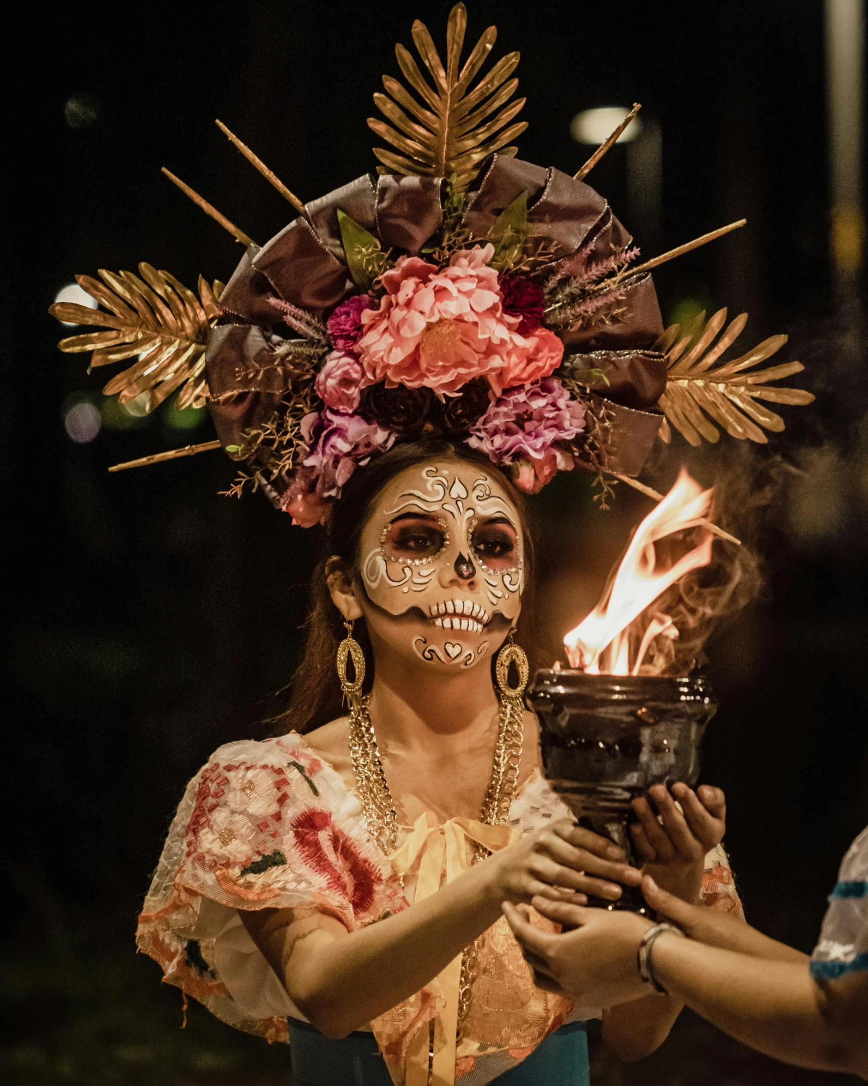 a person wearing a face painted holding a burning object