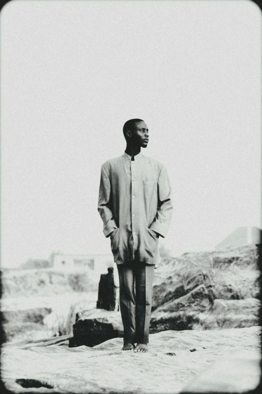 black and white pograph of man standing on a hill