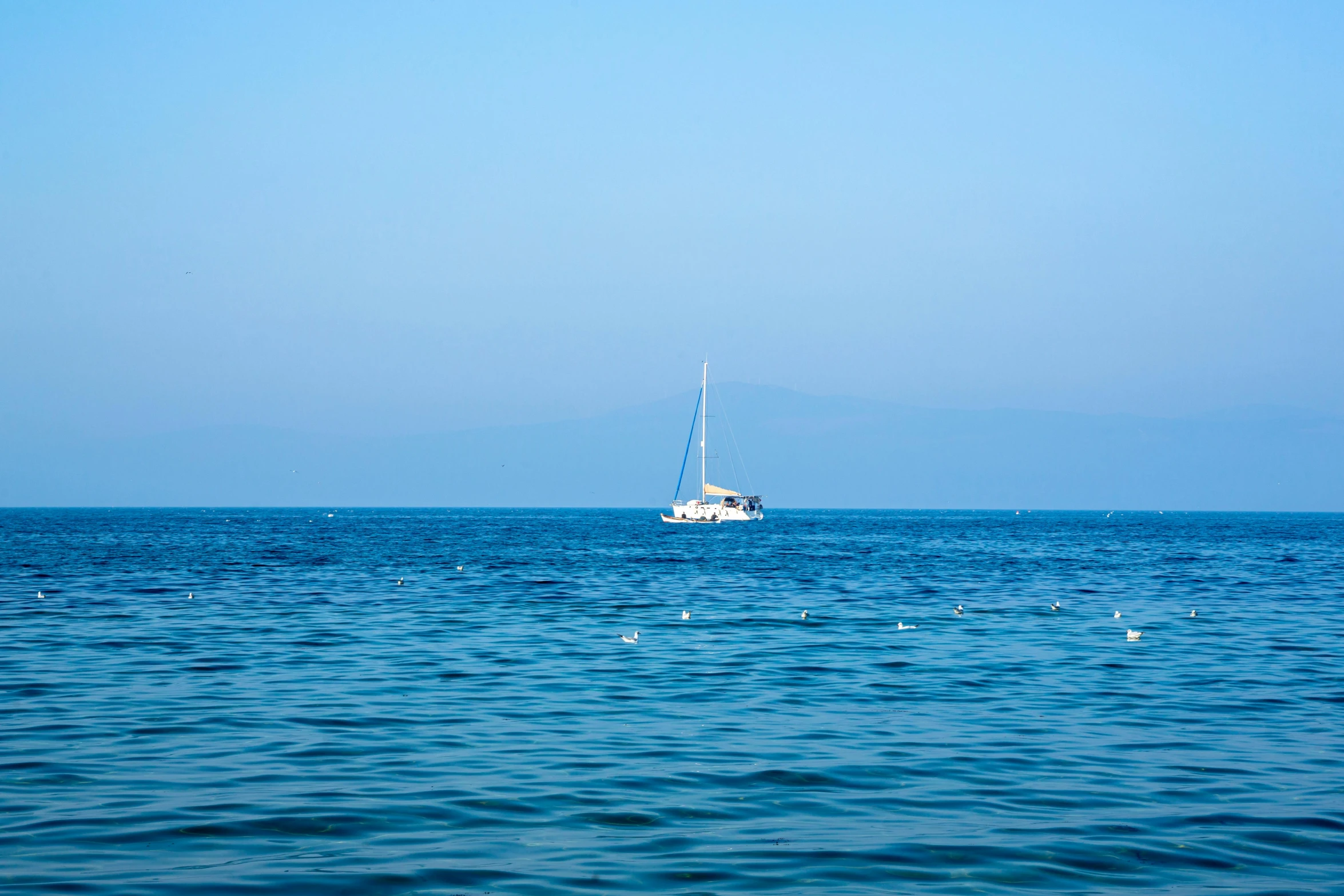 a small boat is in the blue water