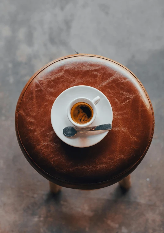 a cup of coffee sitting on a saucer and a spoon