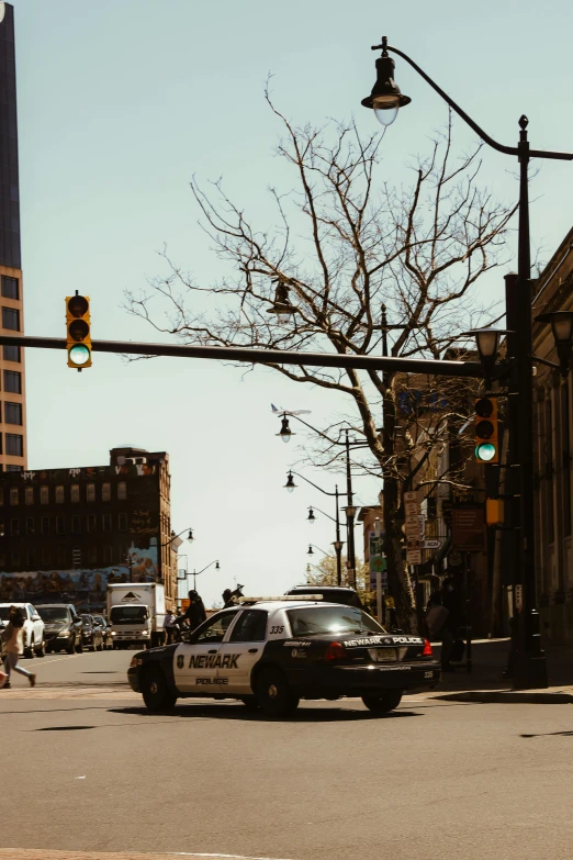 there is a police car on the street at a traffic light