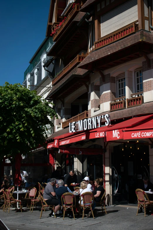 an outdoor cafe with people eating at it