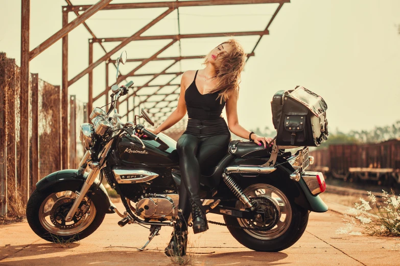 the woman is posing in front of her motorcycle