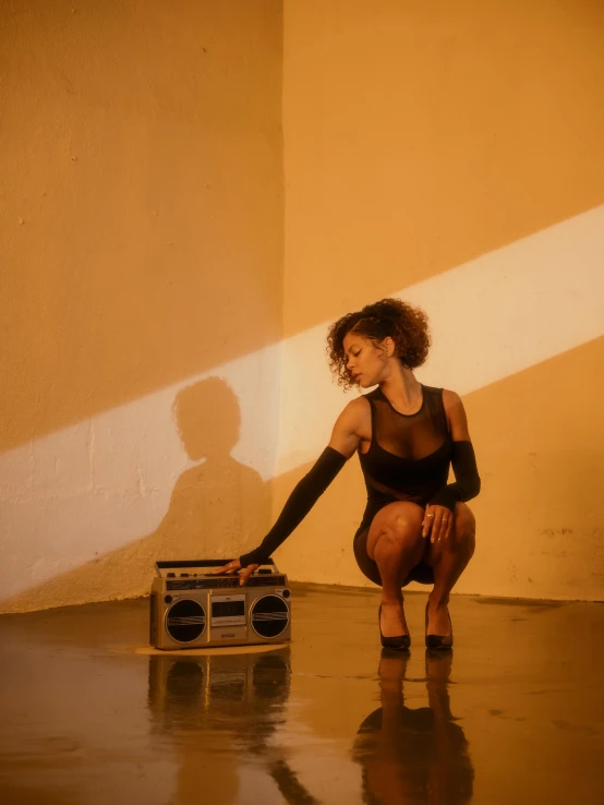 a woman is kneeling by a radio player