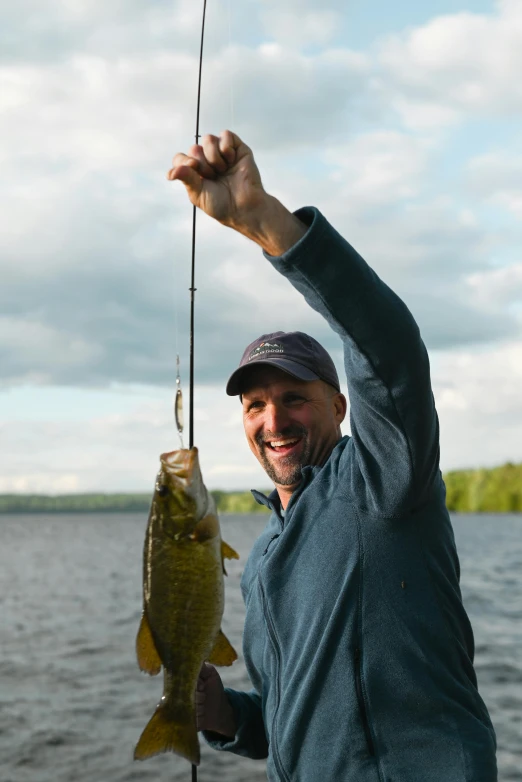 a man holding a fishing pole with a fish