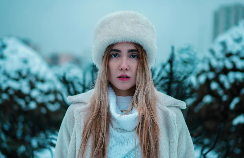 a young woman with long blonde hair and a coat over her