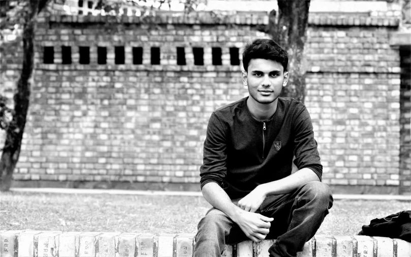 black and white pograph of a man sitting outside