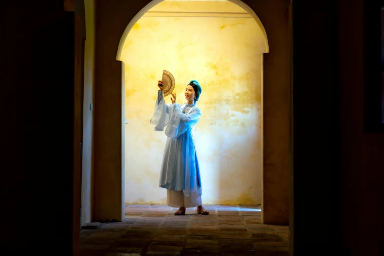 a woman standing in an archway with a glass in hand