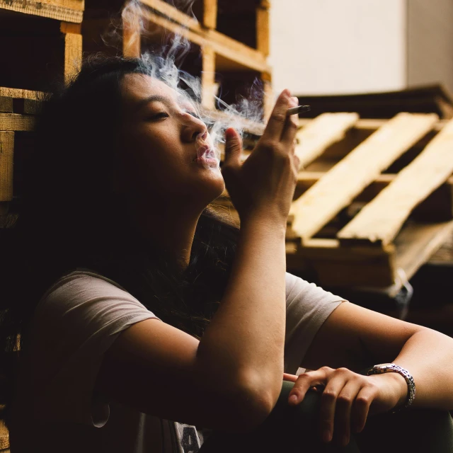 a woman smoking a cigarette with a glass on the side