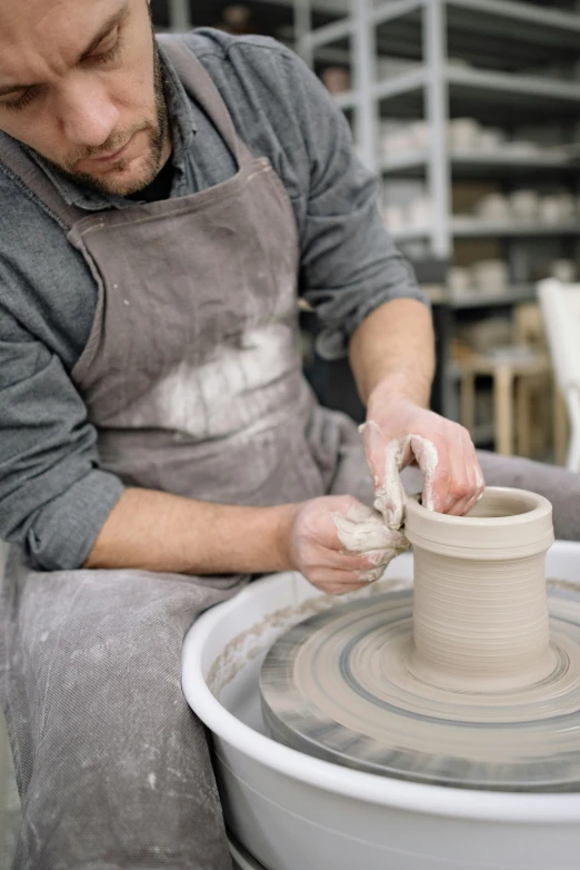 a man using a pottery wheel to shape soing