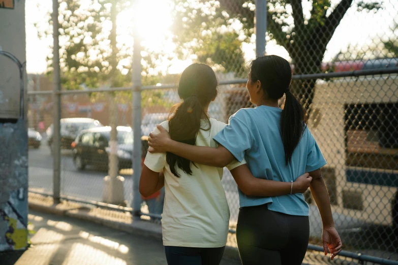 two women walking down the street hugging