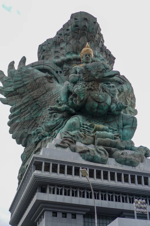 a tall sculpture of an eagle is on top of a building