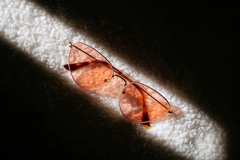 a pair of pink sunglasses casting a shadow on the floor