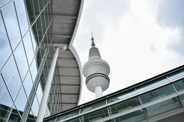 a tall tower near some glass buildings under the sky