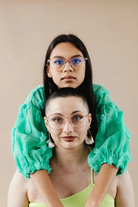 two women dressed in green are facing opposite directions