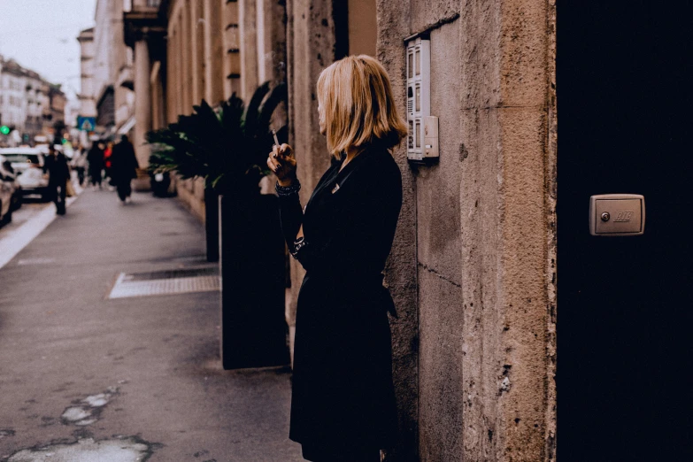 a woman standing on the side of a building