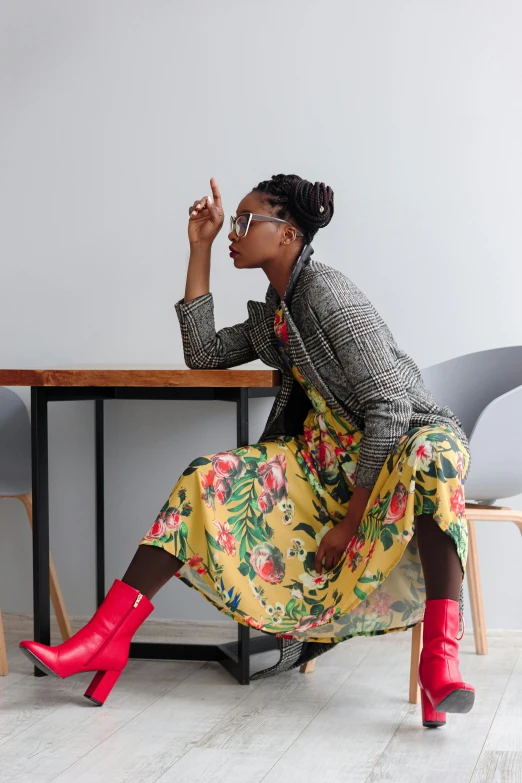 woman sitting at a table smoking a cigarette and wearing bright red boots