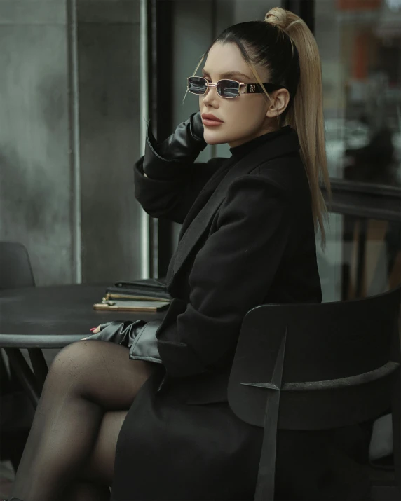 a woman sitting on a chair in tights holding her hand to her ear