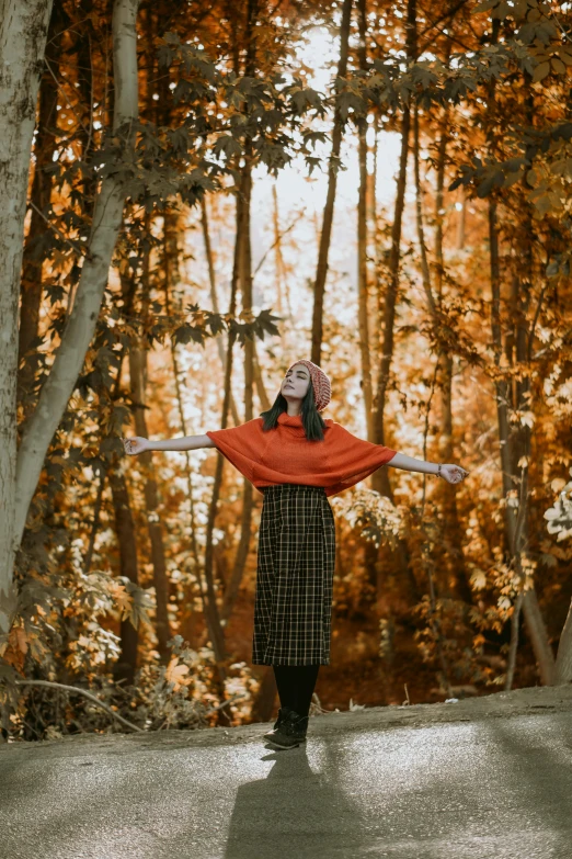 a person standing in a wooded area with an umbrella over their head