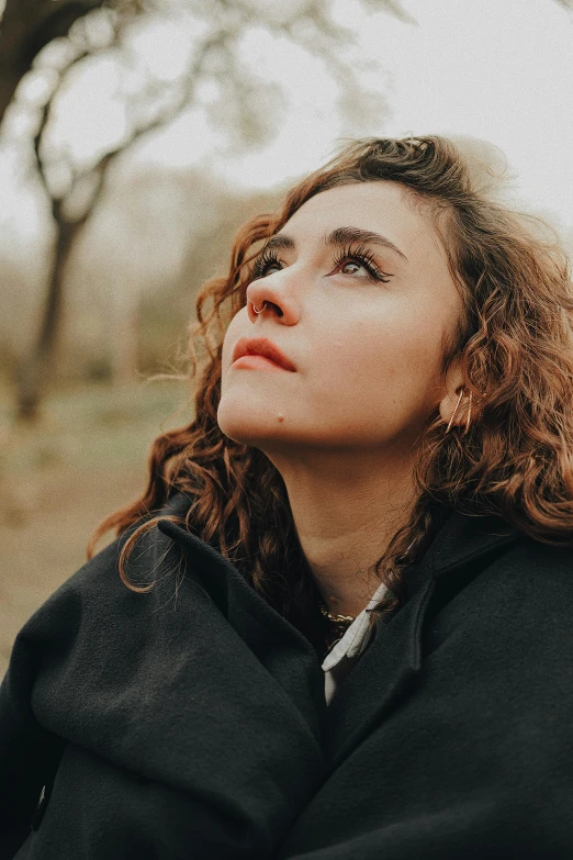 woman looking up while wearing black jacket