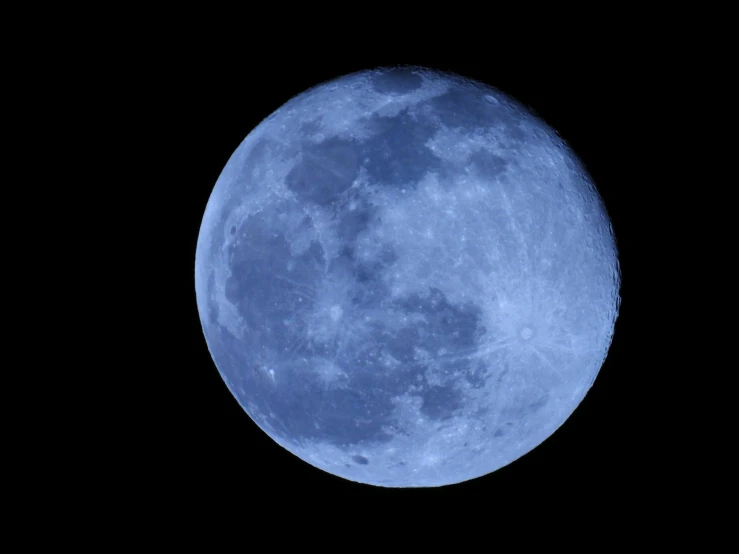 the full blue moon in a dark black sky