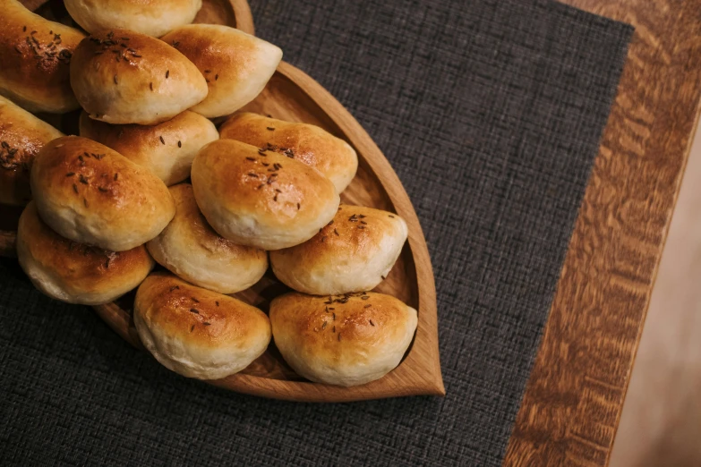 bread rolls arranged in a wooden tray on a table