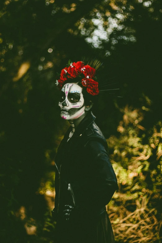 a man in a black jacket wearing skull makeup