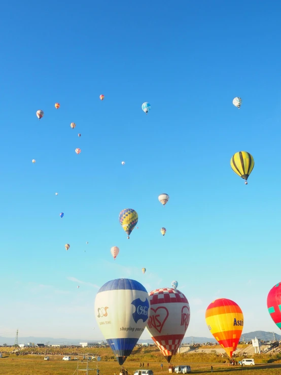 a large group of  air balloons flying through a blue sky