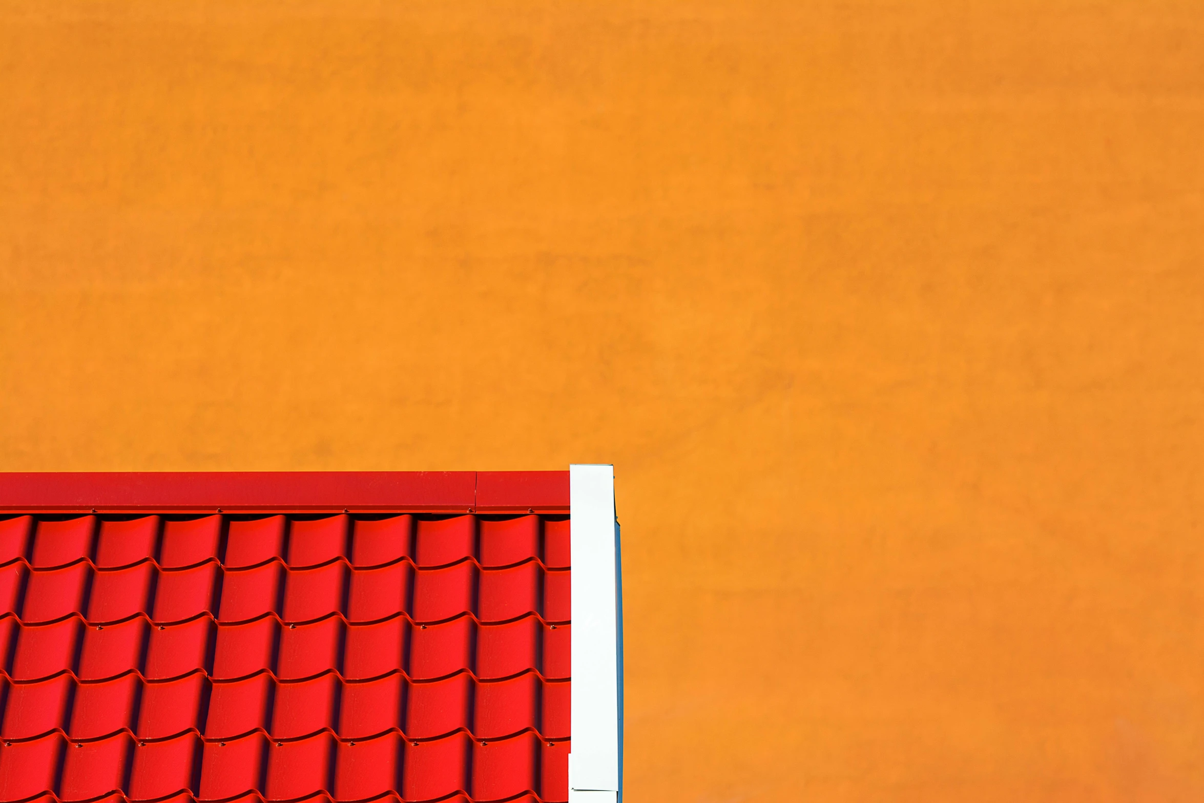 a red tiled roof sits against a yellow wall
