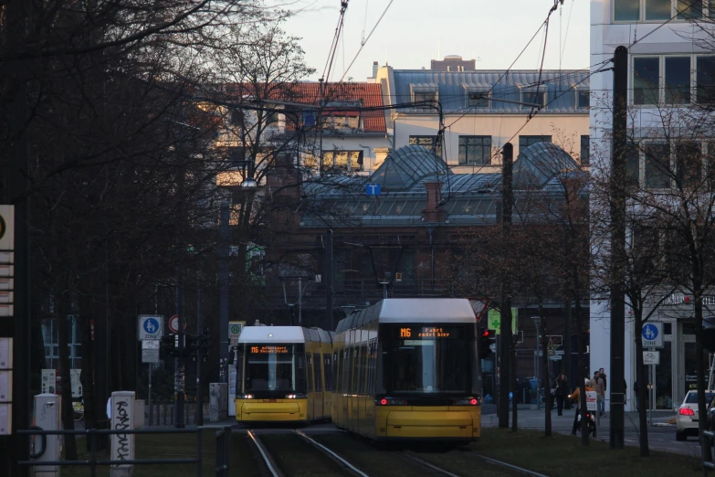 two trains traveling down tracks in the city